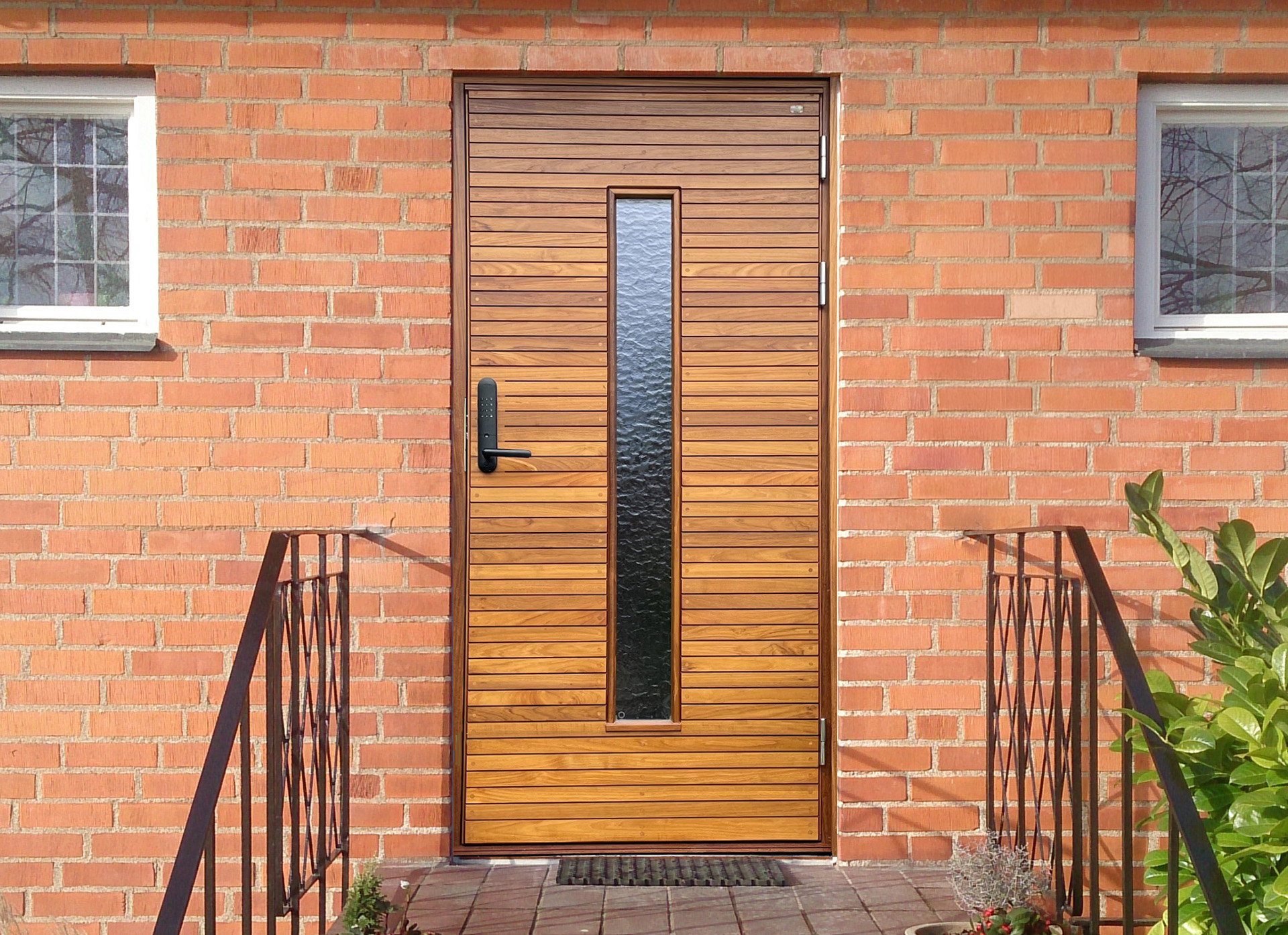 Ytterdörr till rött tegelhus i teak med glas