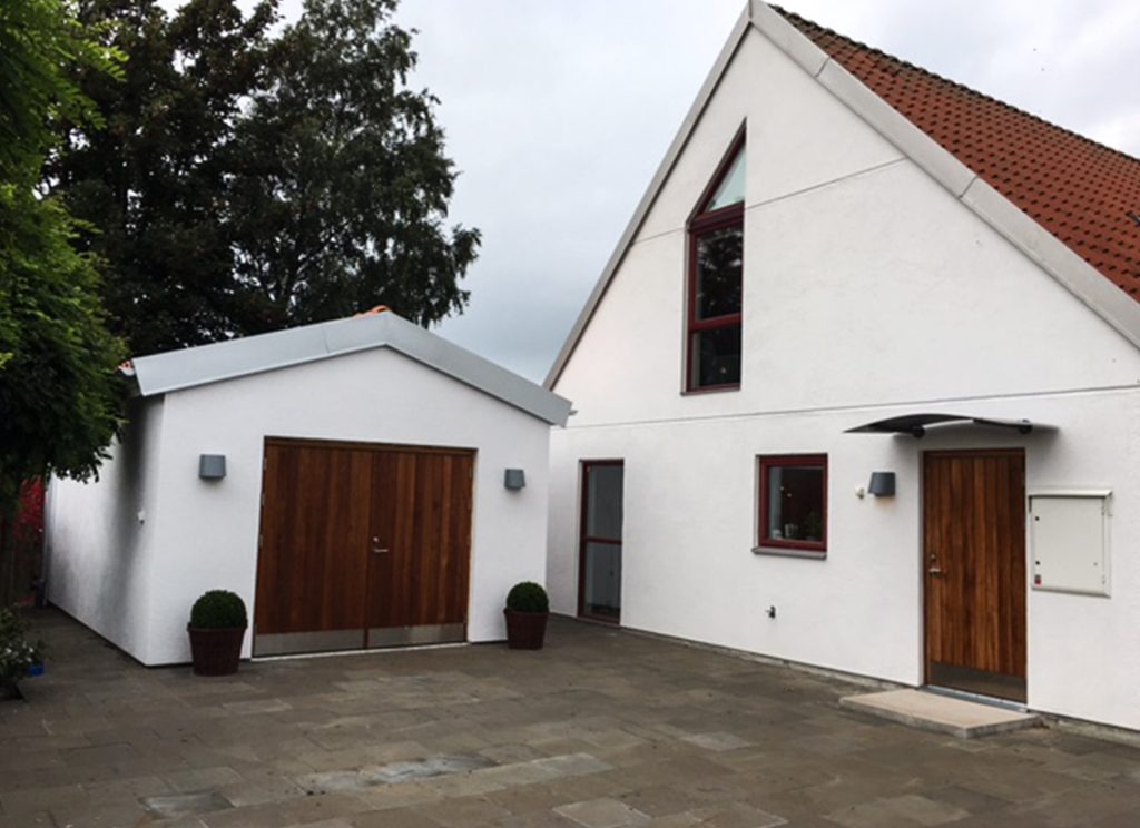 Ytterdörr och garageport i teak till putsad fasad